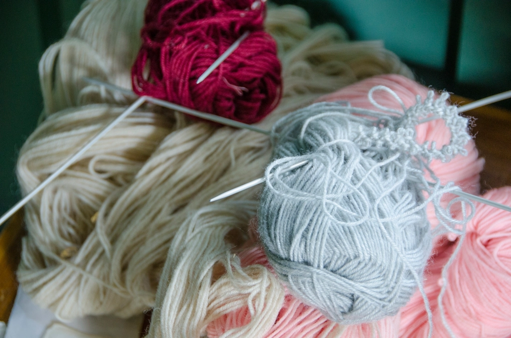 Close up of hands knitting with warm yarn